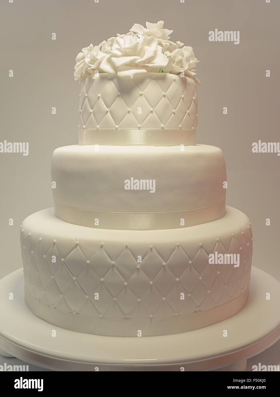 Détails d'un gâteau de mariage, décoration avec fondant blanc sur fond blanc. Banque D'Images
