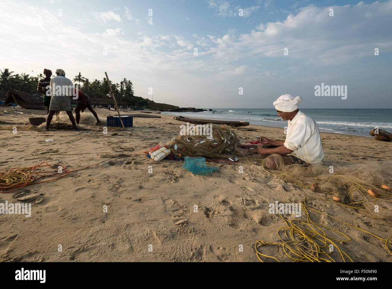 Un pêcheur est la réparation des filets de pêche sur la plage Banque D'Images