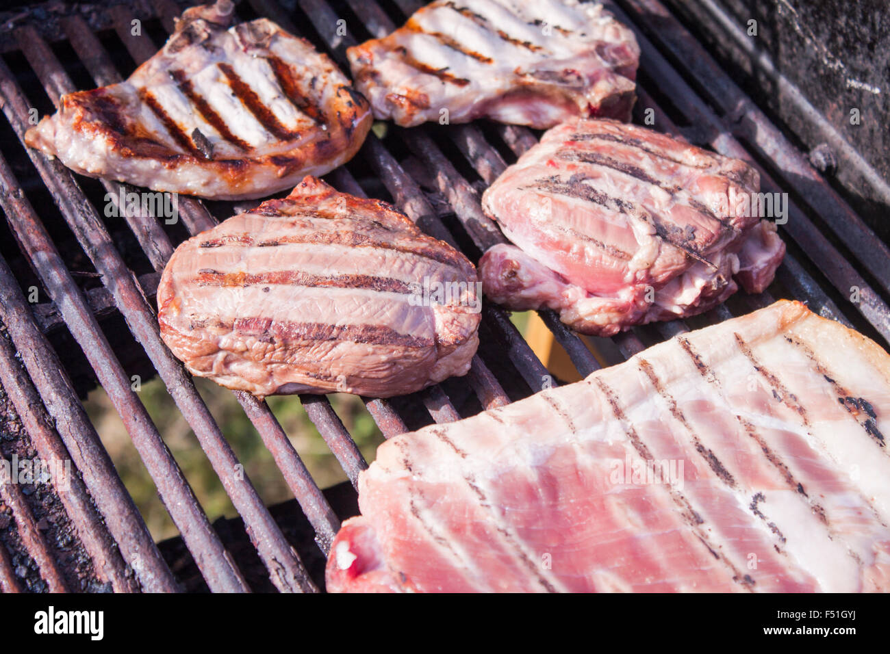 Steak de veau grillé, entre les côtes et côtelettes de porc, sur un barbecue Banque D'Images