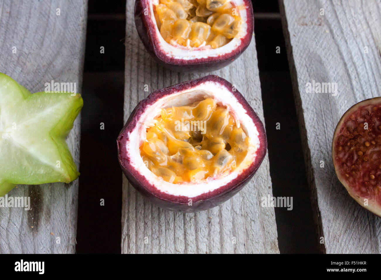Les fruits de la Passion, près de carambole, de prune et d'un autre fruit de la passion, sur sol en bois Banque D'Images
