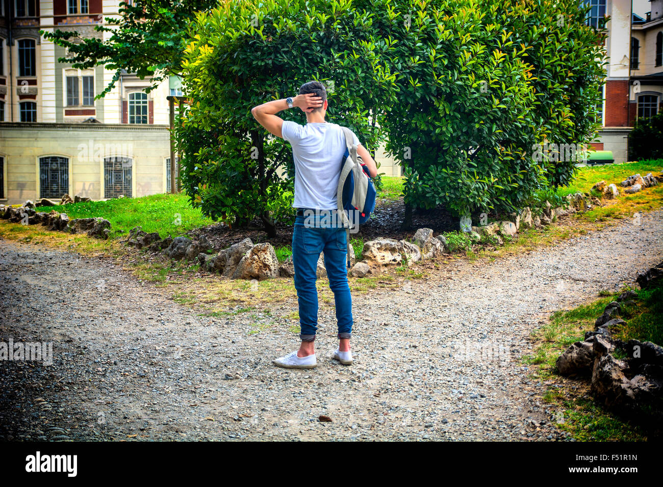 Jeune homme face à choisir entre deux chemins différents. Concept de choisir entre plusieurs options Banque D'Images
