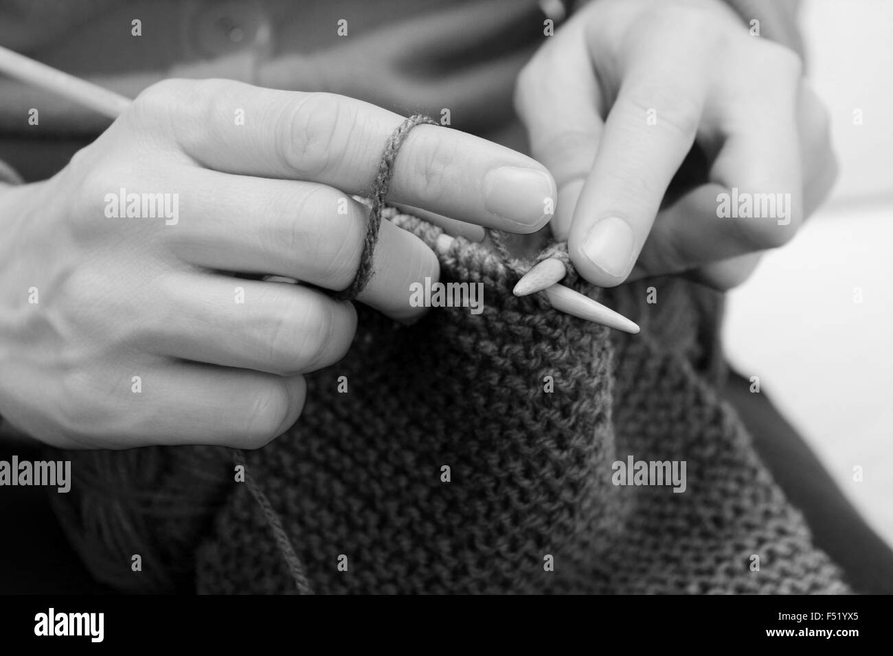 Close up of woman's hands le tricot avec la laine sur les aiguilles en bambou - traitement monochrome Banque D'Images