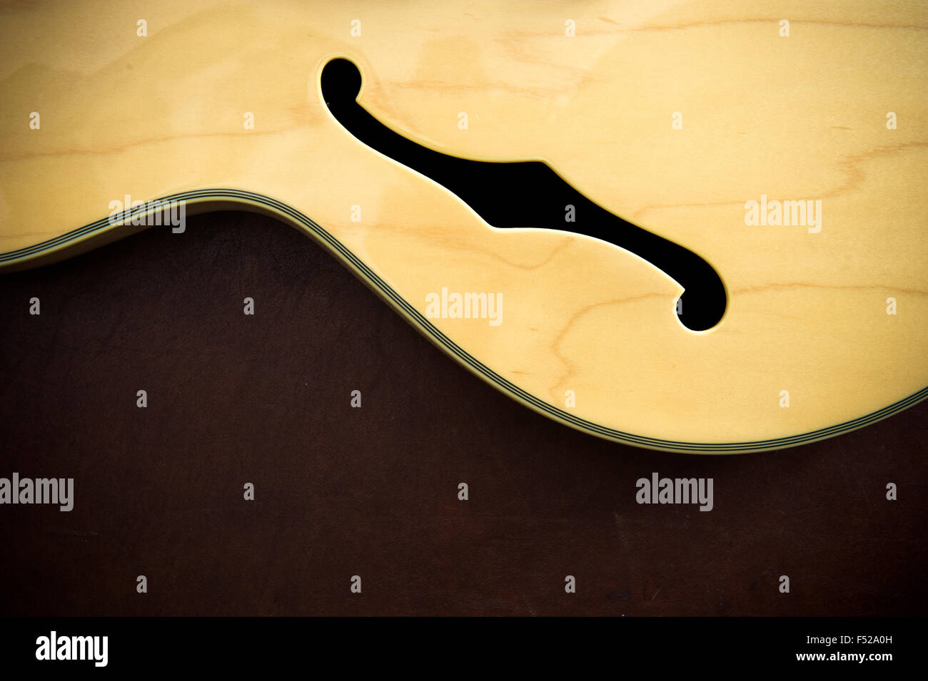 Détail du corps de guitare avec du son f-trous sur fond de bois, look vintage Banque D'Images