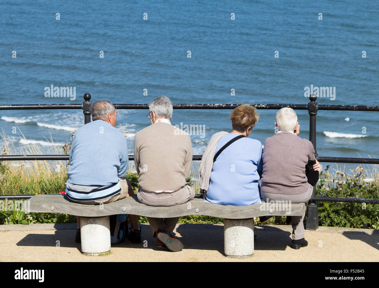 Les couples âgés assis sur son fauteuil avec vue sur la mer. UK Banque D'Images