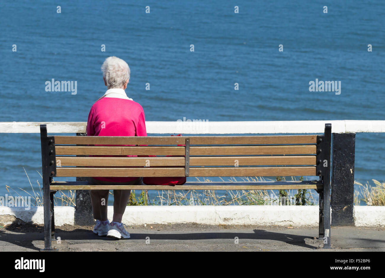 Vieille Femme assis sur son fauteuil avec vue sur la mer. UK Banque D'Images