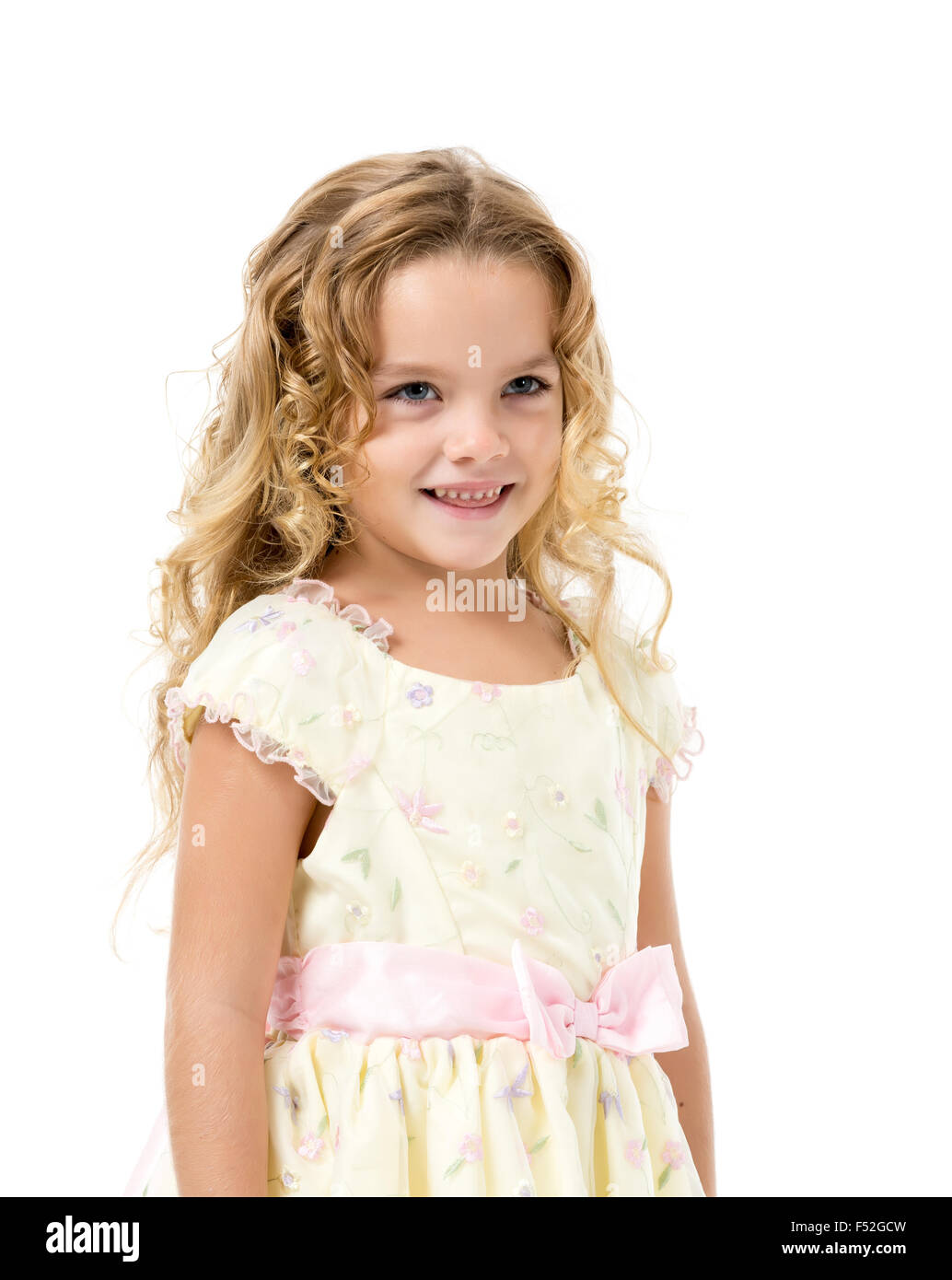 Petite fille dans une robe de lumière, posant sur fond blanc Banque D'Images