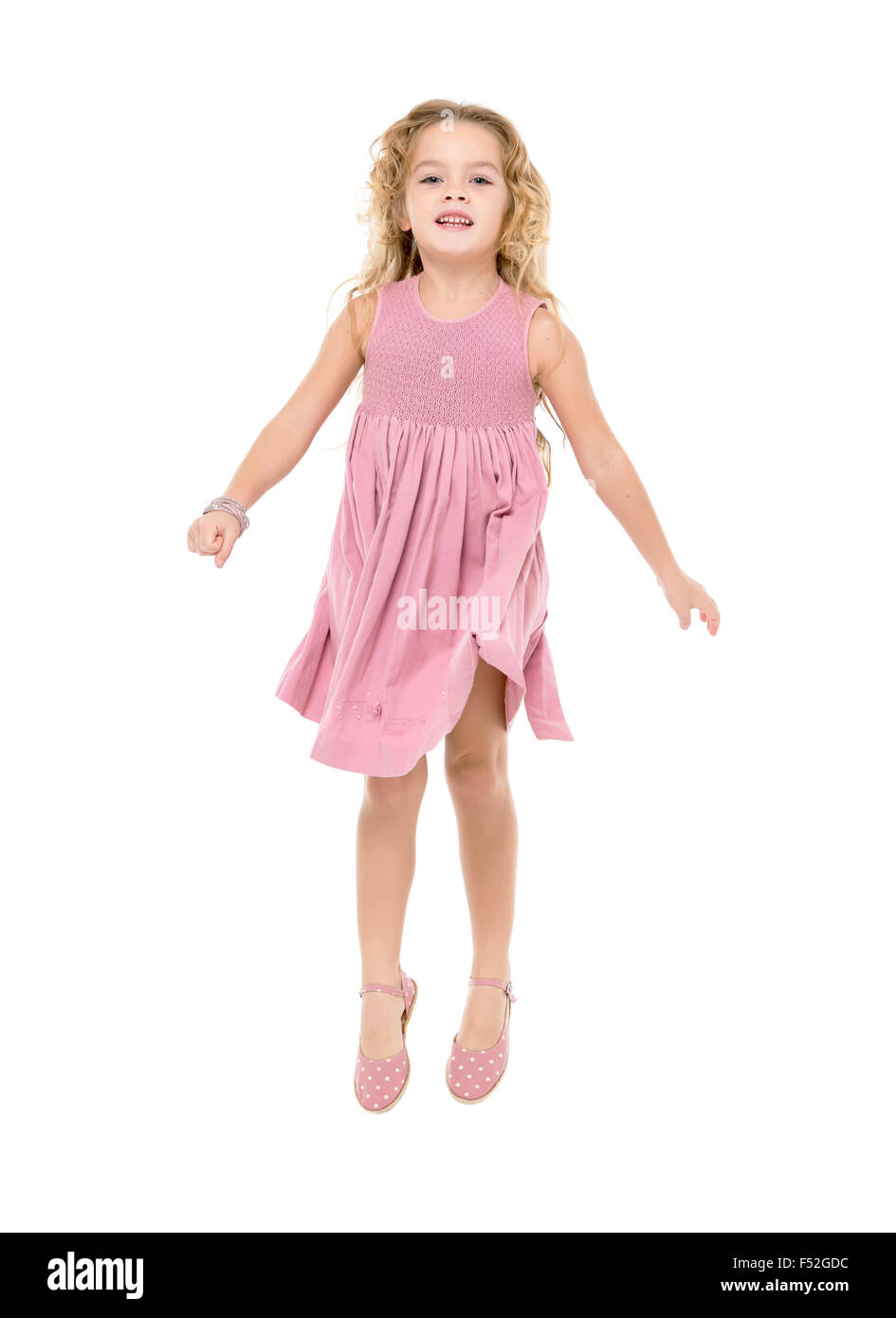 Petite fille dans une robe rose sauter, sur fond blanc Banque D'Images