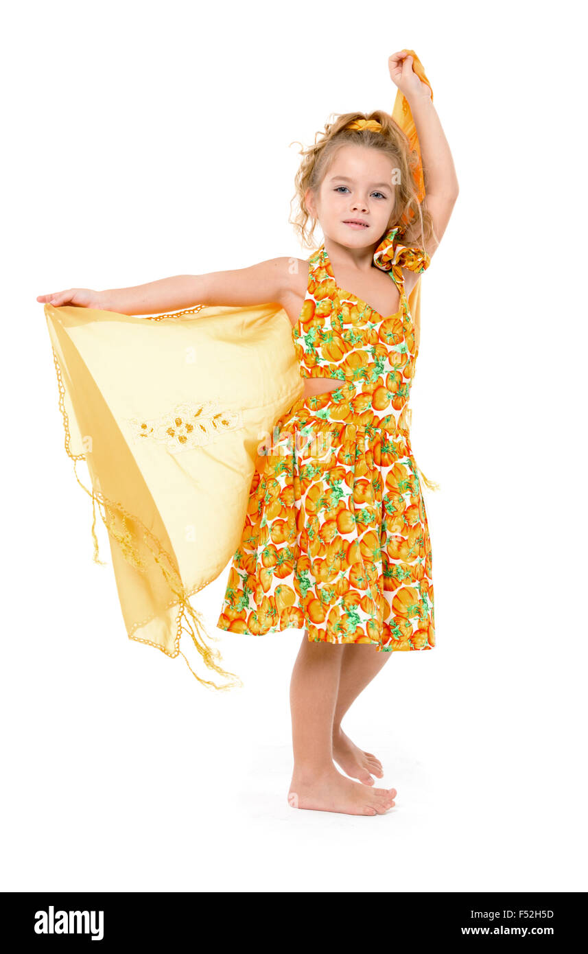 Petite fille dans une robe jaune avec châle posant, sur fond blanc Banque D'Images