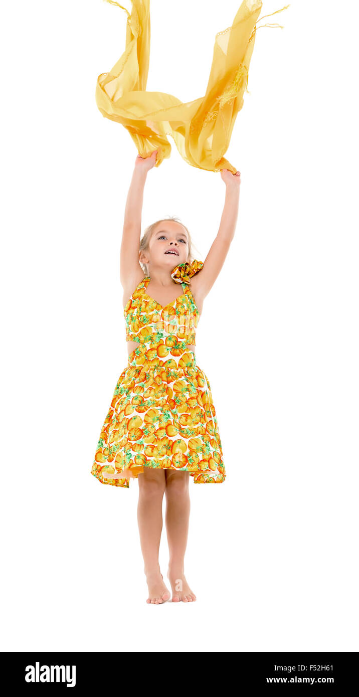 Petite fille dans une robe jaune lance de châle, sur fond blanc Banque D'Images