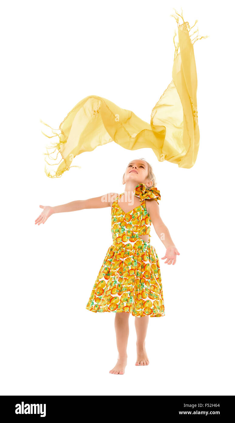 Petite fille dans une robe jaune lance de châle, sur fond blanc Banque D'Images