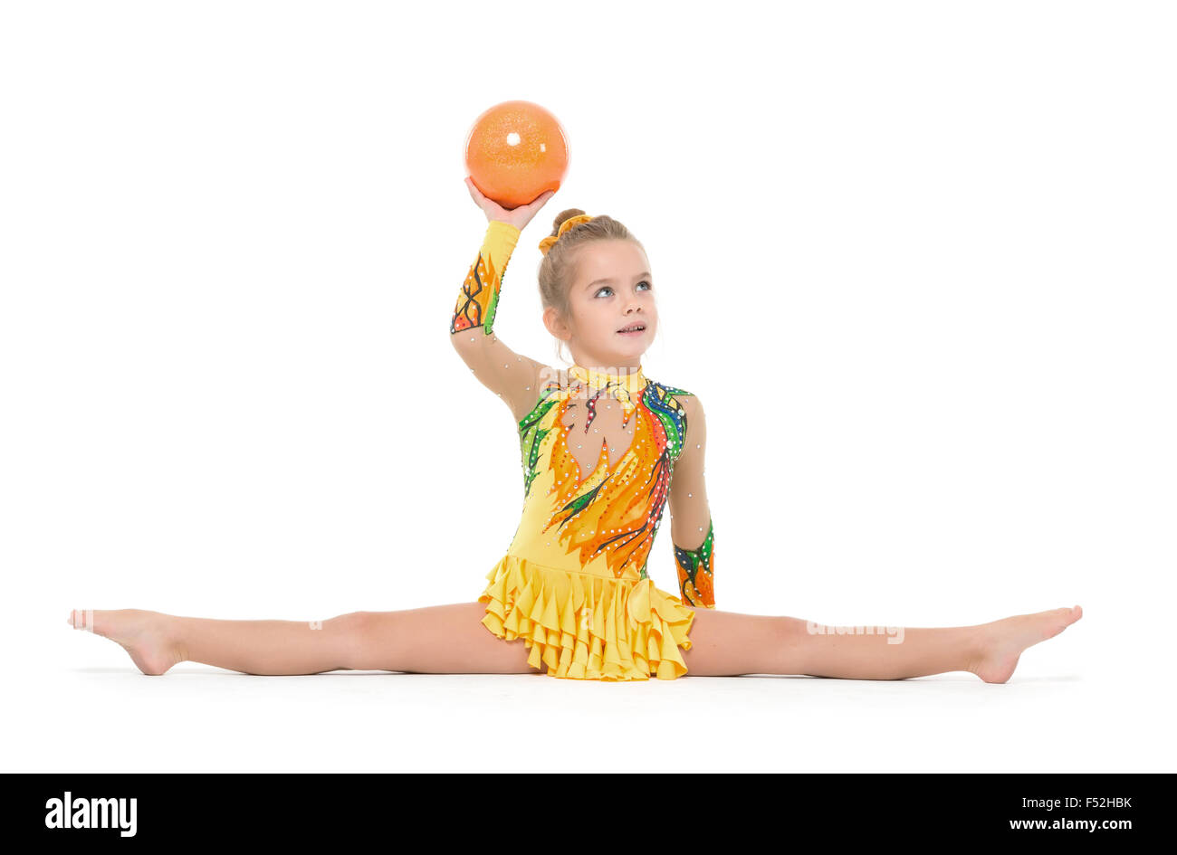 Gymnaste peu pratiquant avec un ballon, sur fond blanc Banque D'Images