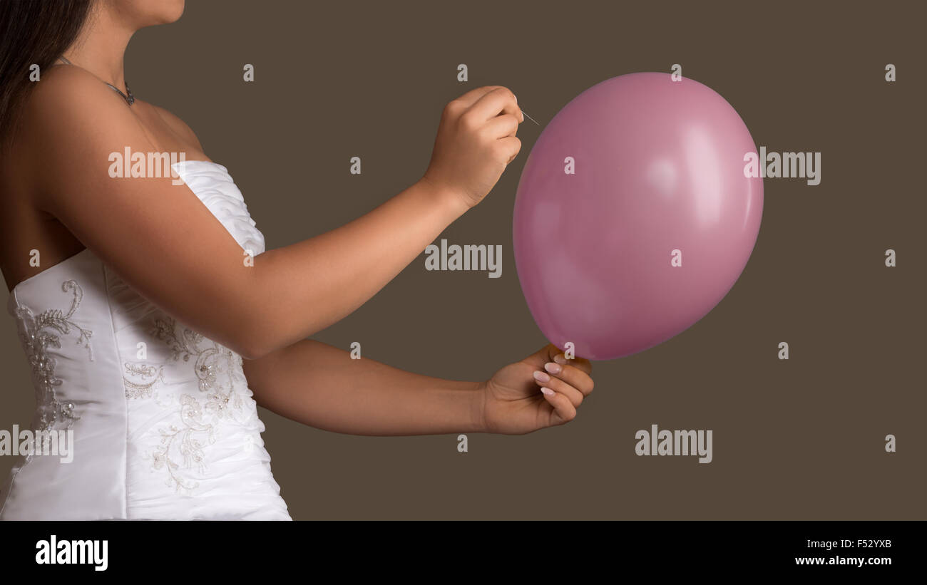 Jeune femme en robe de mariage vous permet d'un ballon a éclaté avec une aiguille Banque D'Images