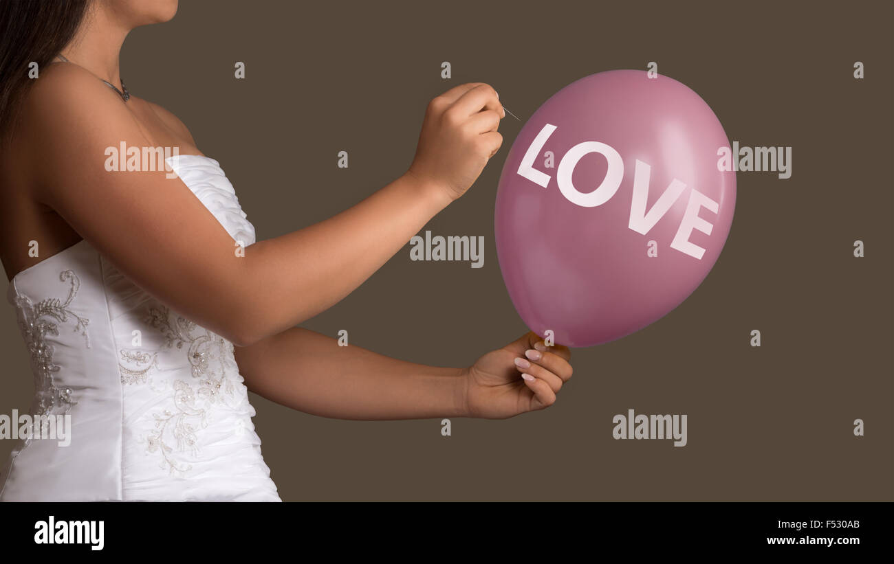 Jeune femme en robe de mariage vous permet d'un ballon avec l'éclatement du texte avec une aiguille Banque D'Images