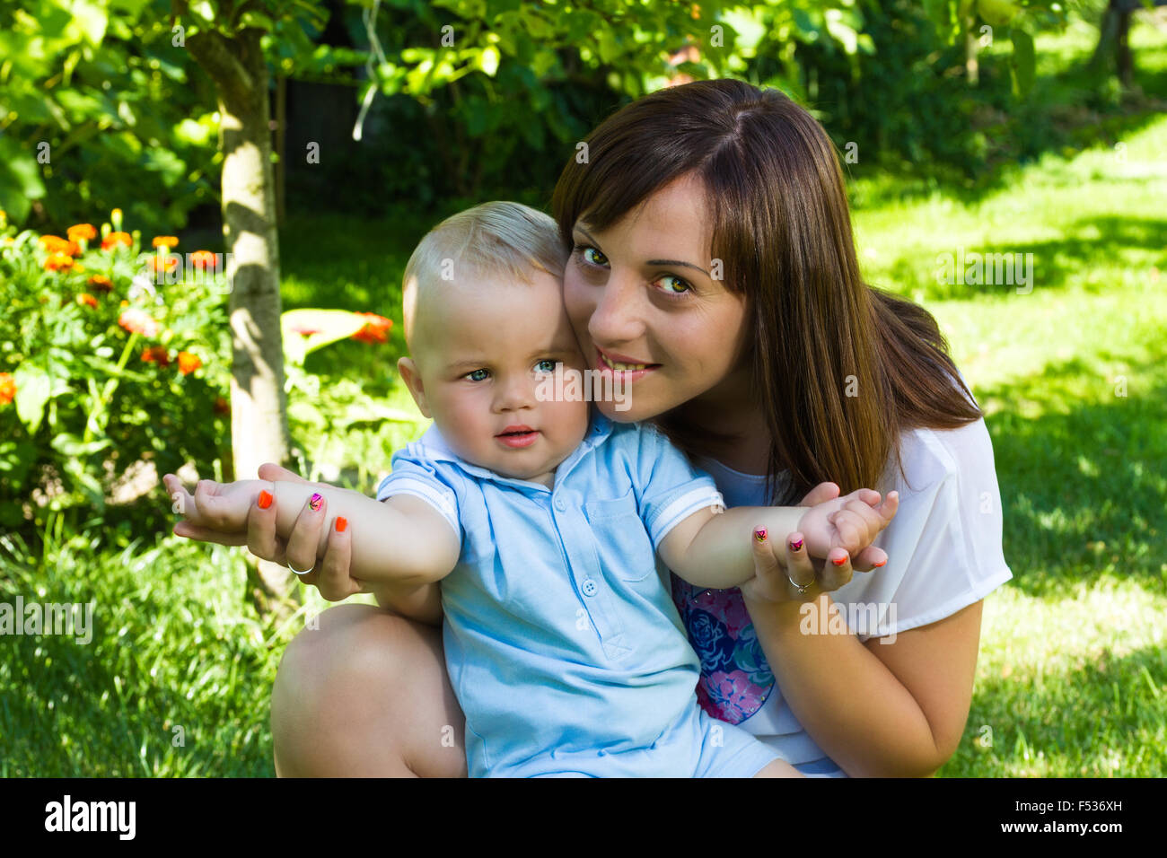 Charmant caucasian baby boy with mother in garden Banque D'Images