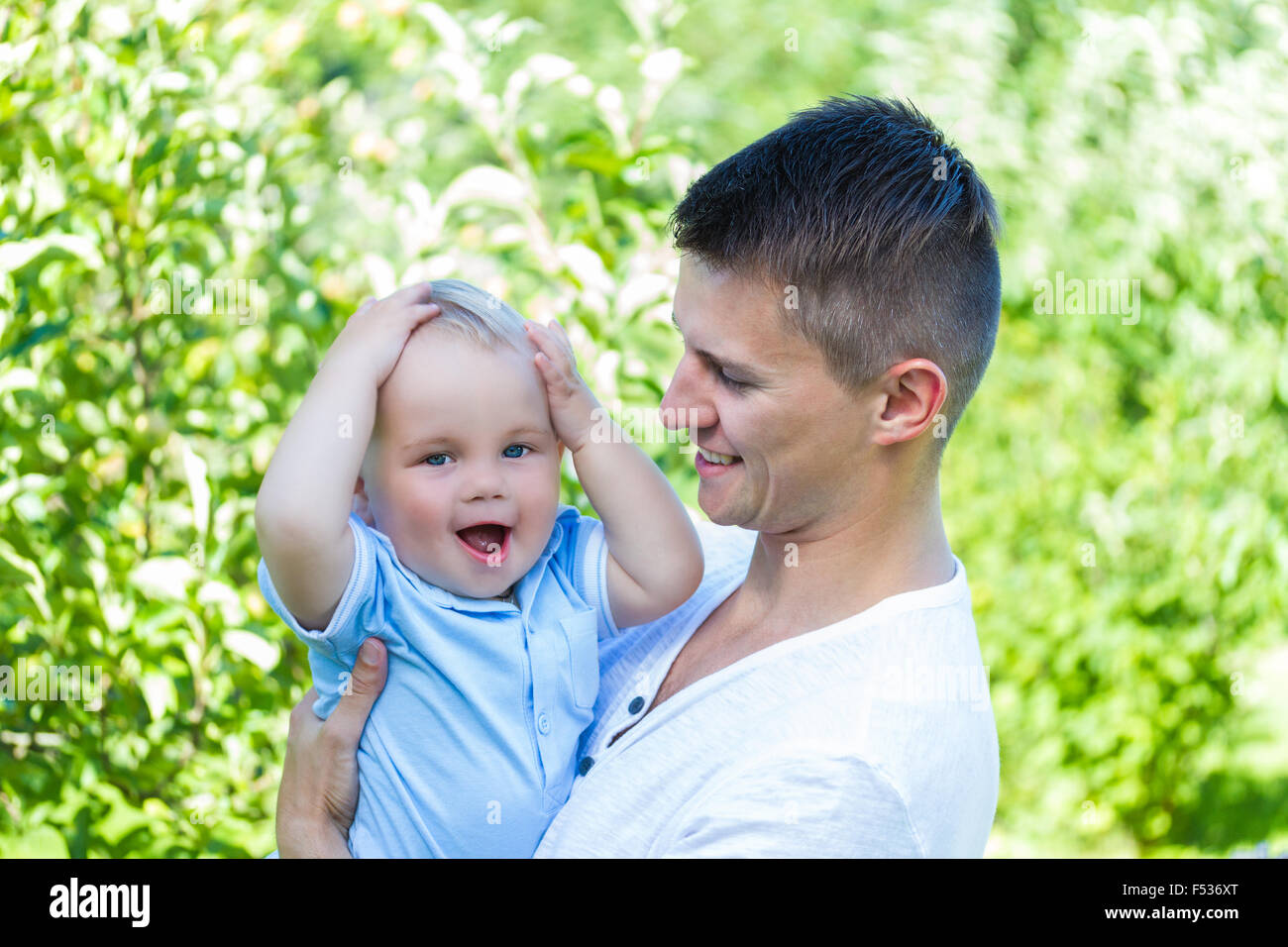 Charmant caucasian baby boy avec le père dans le jardin Banque D'Images