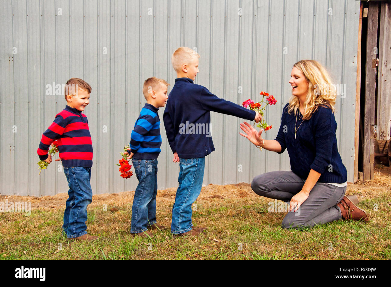 Les garçons offrir à maman fleurs Banque D'Images
