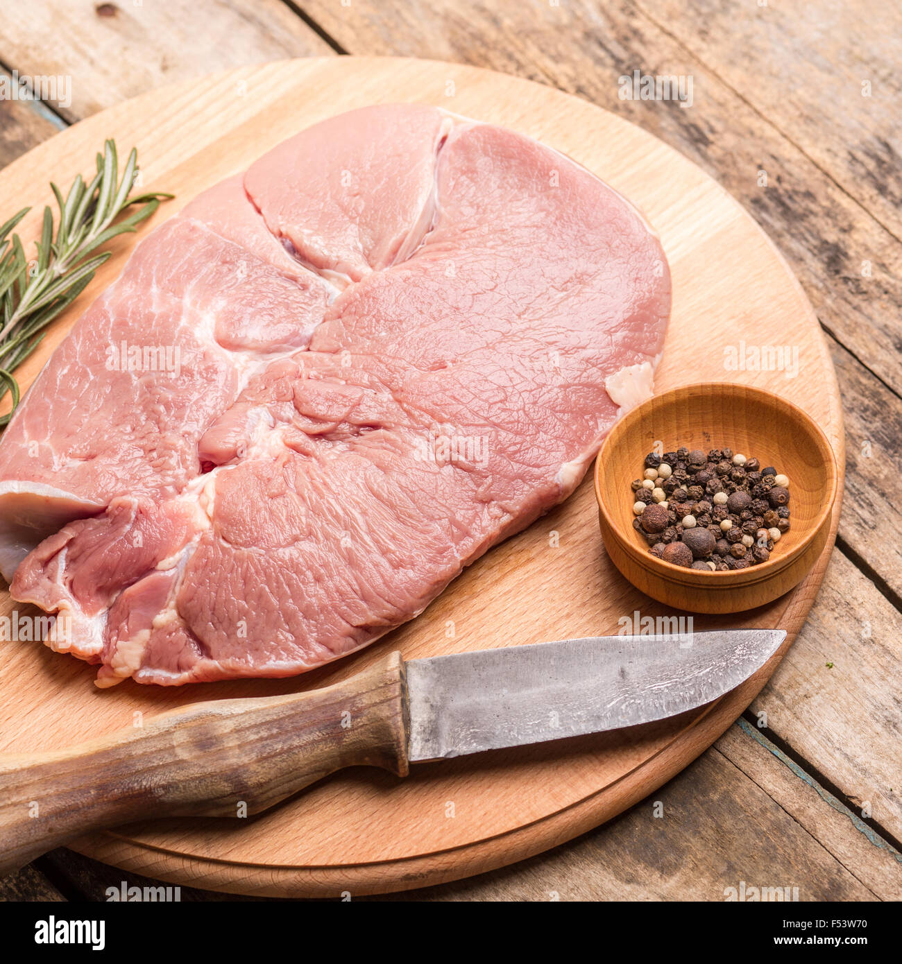 Morceau de viande avec le couteau et le poivre sur fond de bois. Arrière-plan de recette et menu Beefsteak Banque D'Images