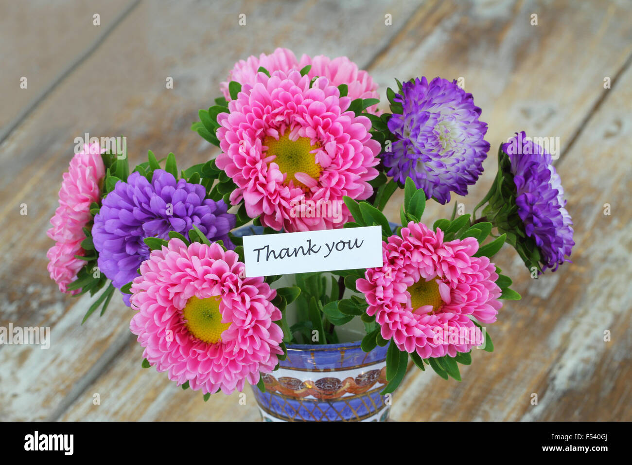 Carte de remerciement avec bouquet de fleurs colorées aster sur la surface en bois rustique Banque D'Images