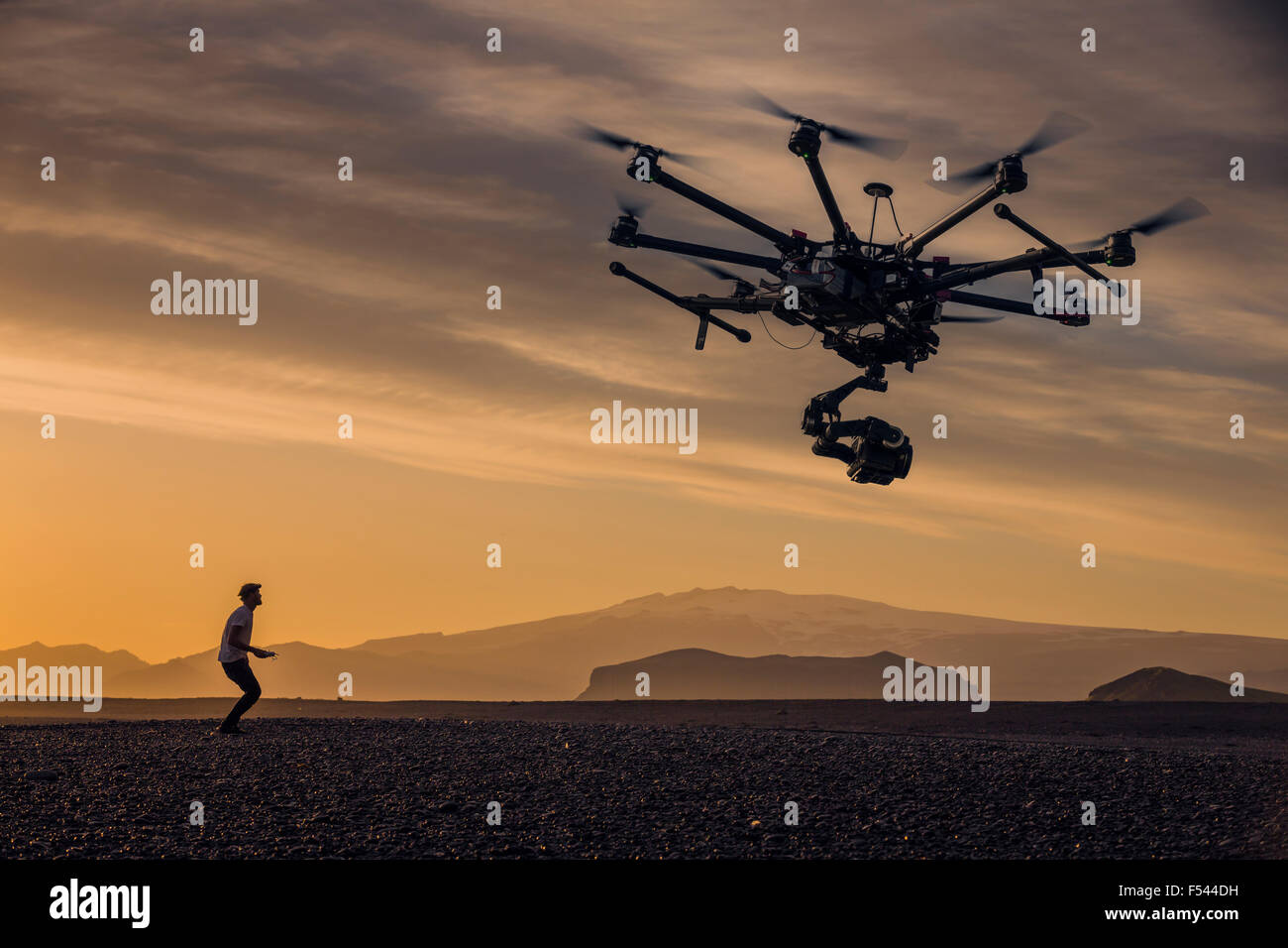 L'homme aux commandes d'un drone contrôlé à distance avec un appareil photo au coucher du soleil sur les hauts plateaux du centre, de l'Islande Banque D'Images