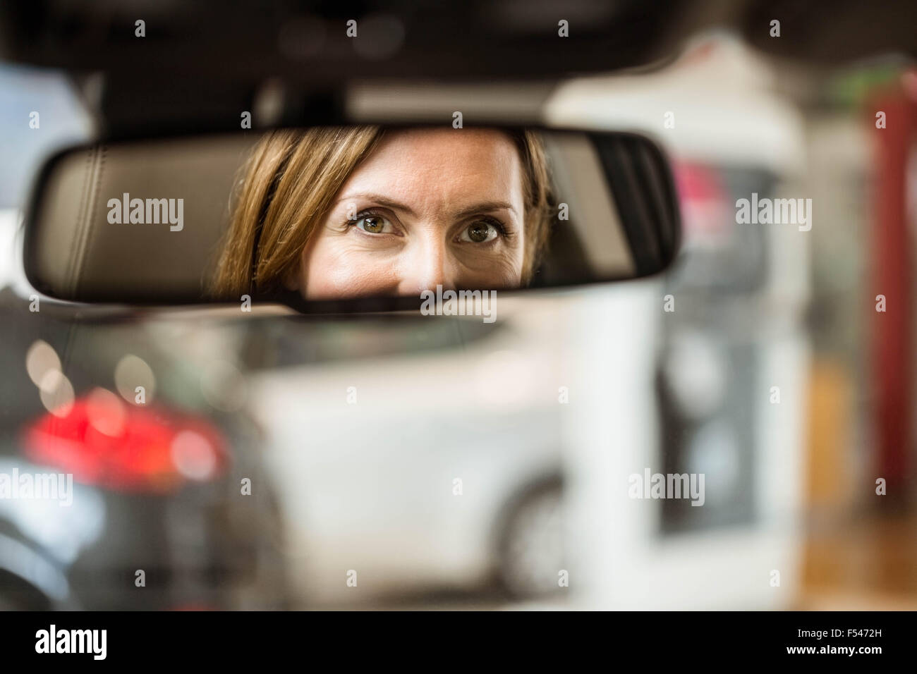 Jeune femme dans le siège du conducteur à la recherche dans le miroir Banque D'Images