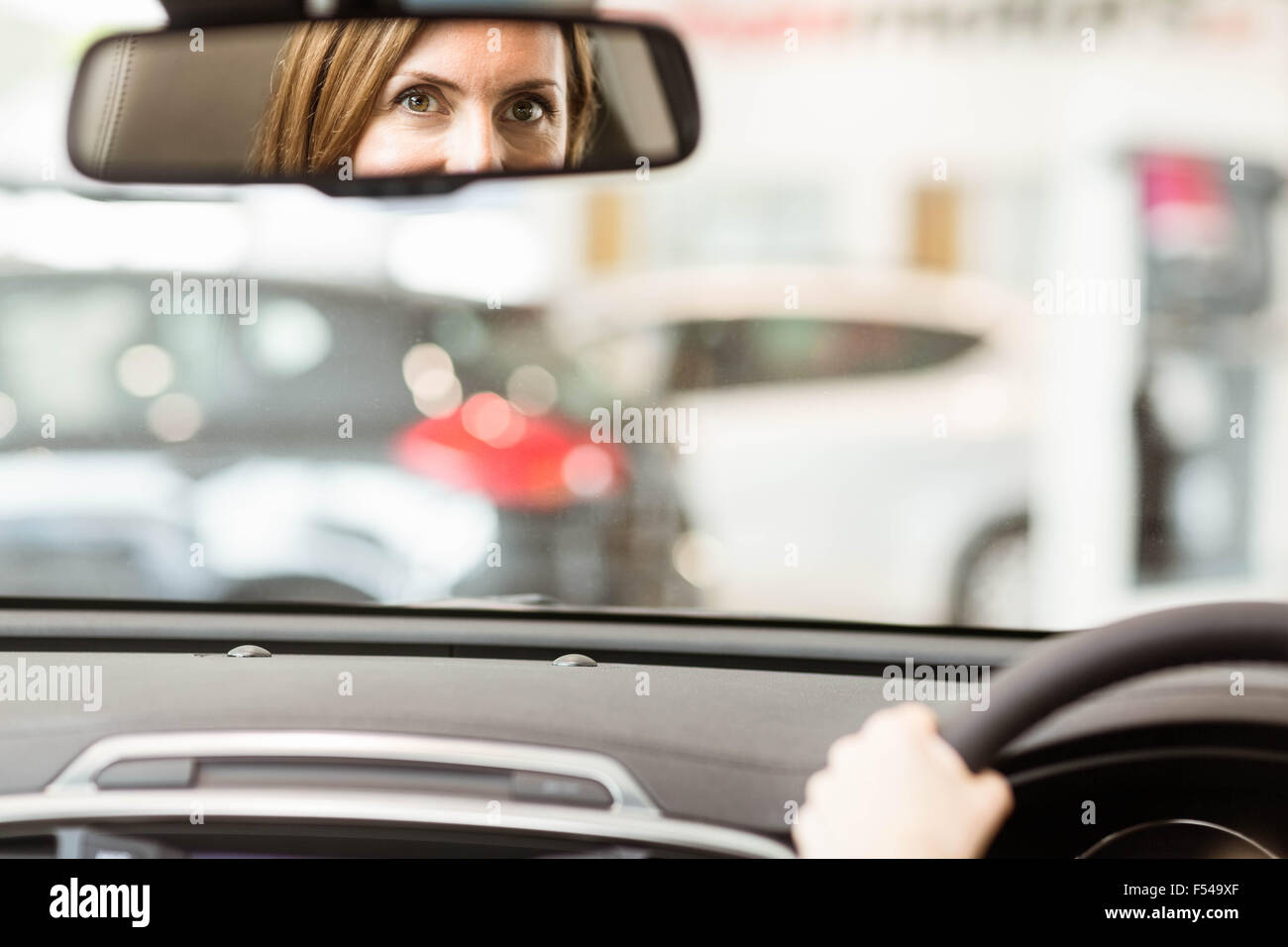 Jeune femme dans le siège du conducteur à la recherche dans le miroir Banque D'Images