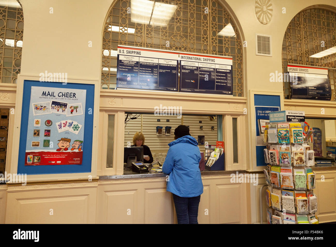 Une femme d'acheter des timbres dans l'intérieur d'un bureau de poste, New Hampshire USA Banque D'Images