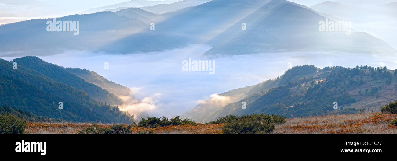 Matin d'automne sur la montagne avec sunbeam et haze. Banque D'Images