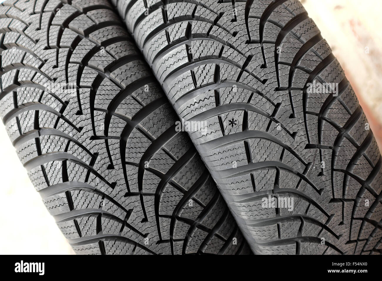 Tout nouveau pneu neige hiver pour voiture montrant la bande de roulement en caoutchouc profil avec gorges profondes, vue en gros plan. Banque D'Images
