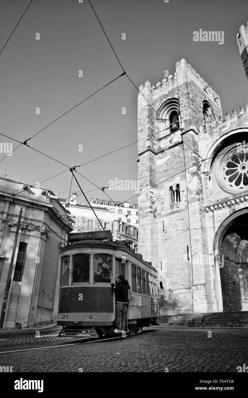 Vintage ancien tramway 28 dans Alfama et cathédrale se en bas aux passagers clandestins Banque D'Images