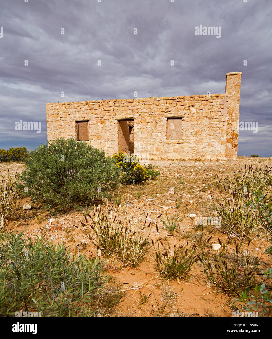 Ruines du 19ème siècle historique Carcory homestead cottage en pierre, entourée de plantes indigènes sous ciel d'orage, outback Australie Banque D'Images