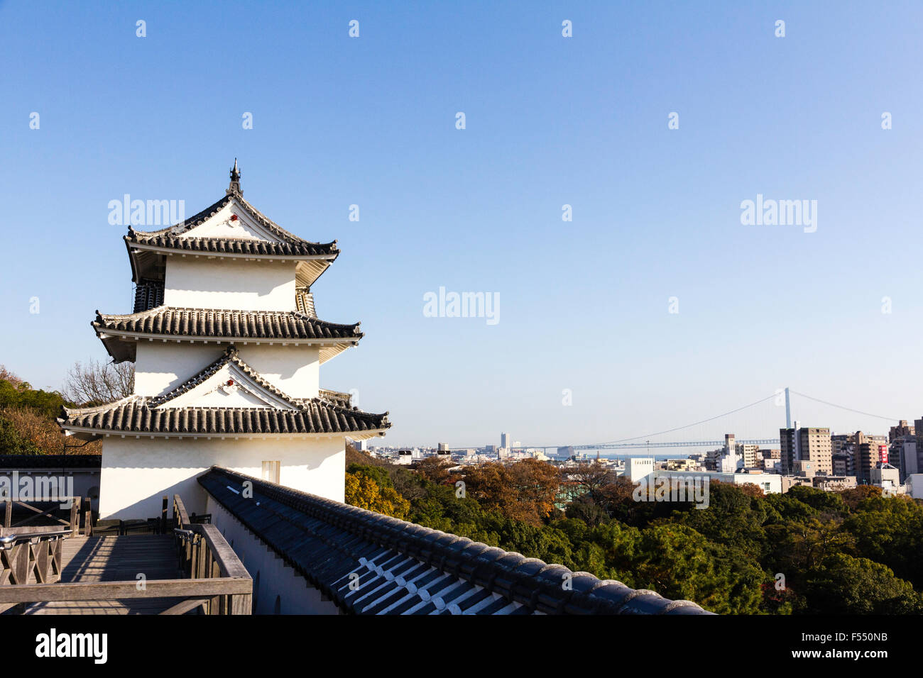 Le Japon, Nishi-Akashi. Haut de la colline du château d'Akashi. La yagura Tatsumi, une tourelle de trois étages. Vue depuis le long mur dobei. Pont d'Akashi en arrière-plan. Banque D'Images