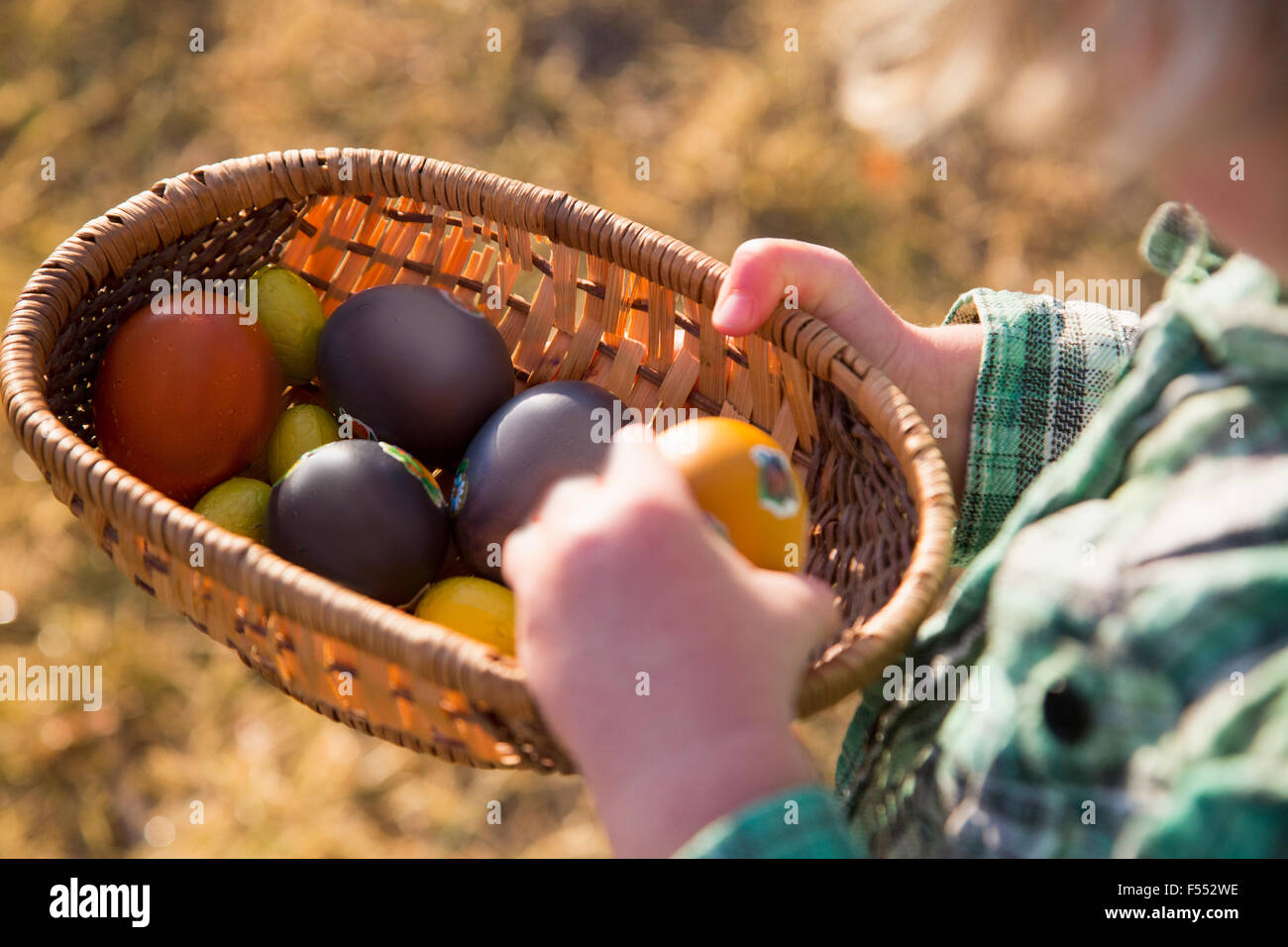 Portrait enfant tenant des oeufs de Pâques dans le panier à l'extérieur Banque D'Images