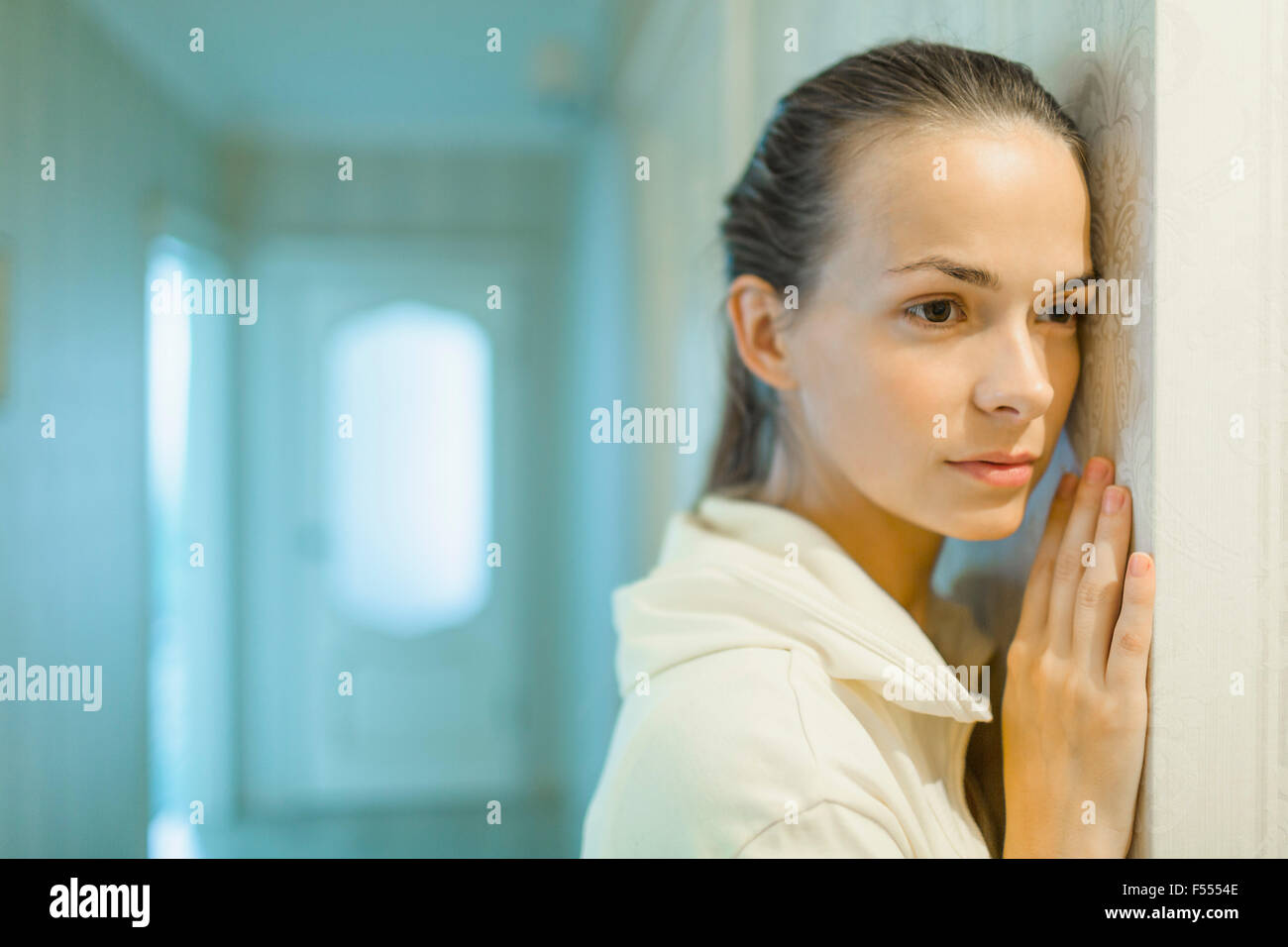 Belle femme à la voiture tout en se penchant sur le mur à la maison Banque D'Images
