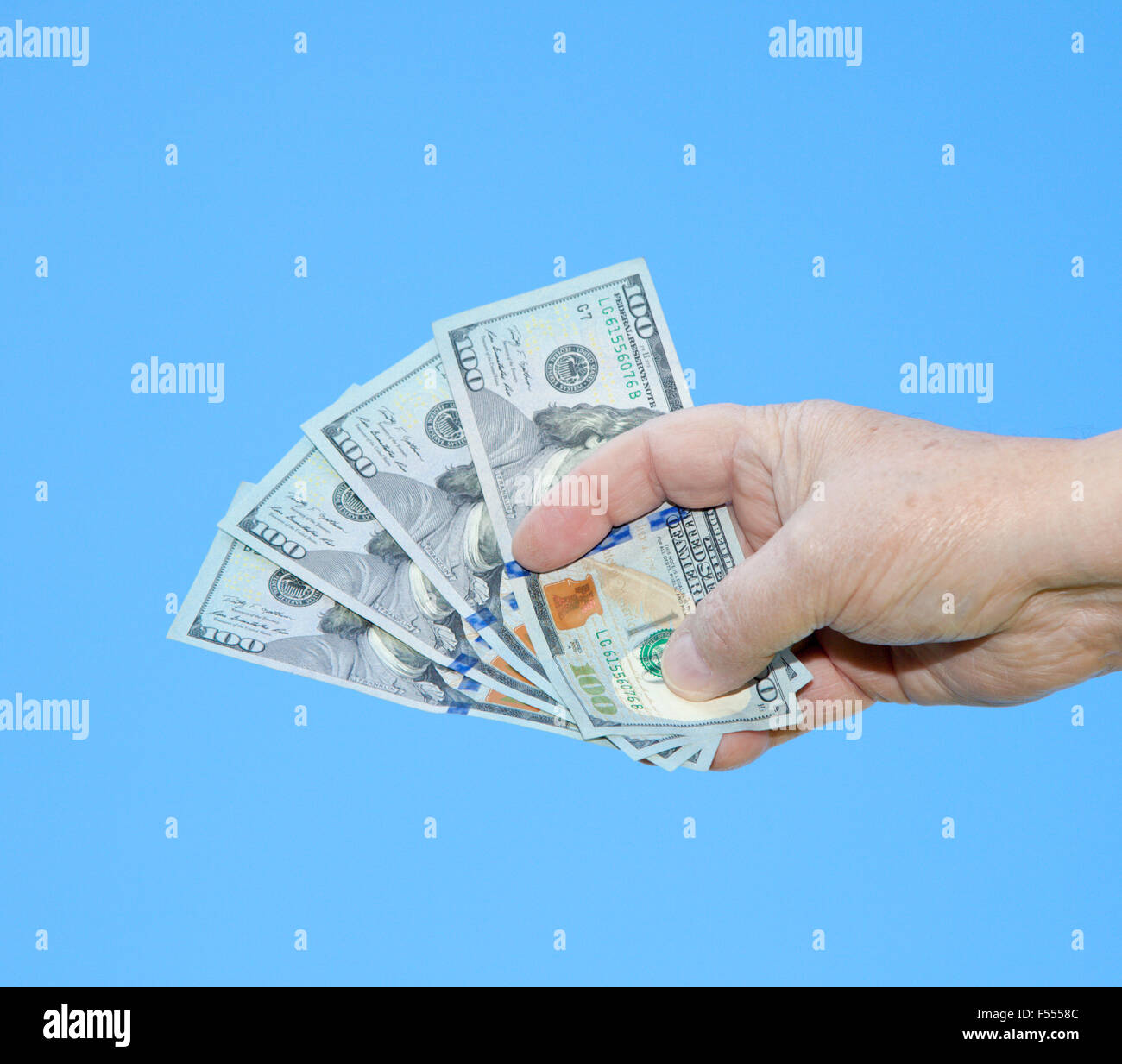 Hand holding dollar note en face de ciel bleu Banque D'Images