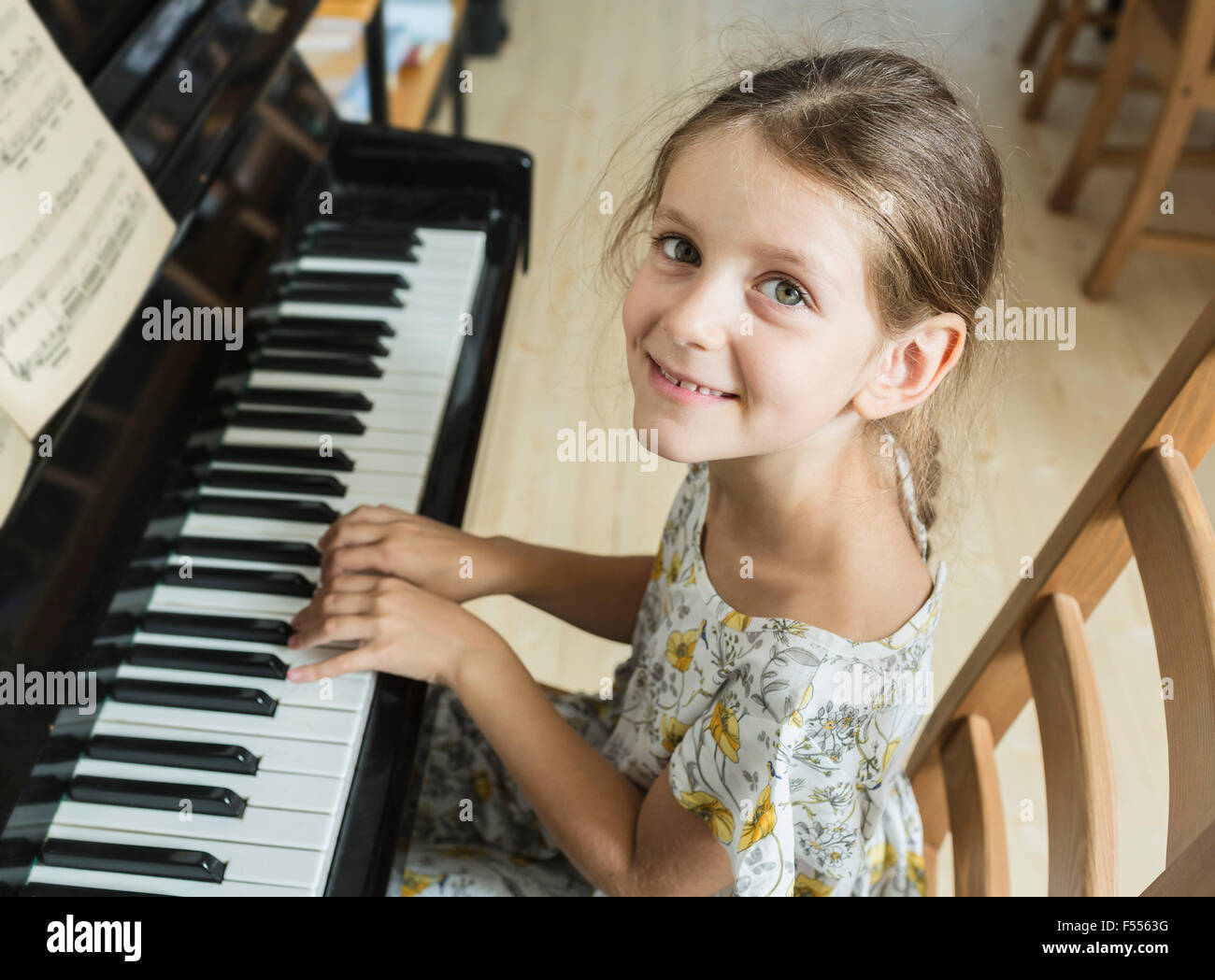 High angle portrait of girl playing piano at home Banque D'Images