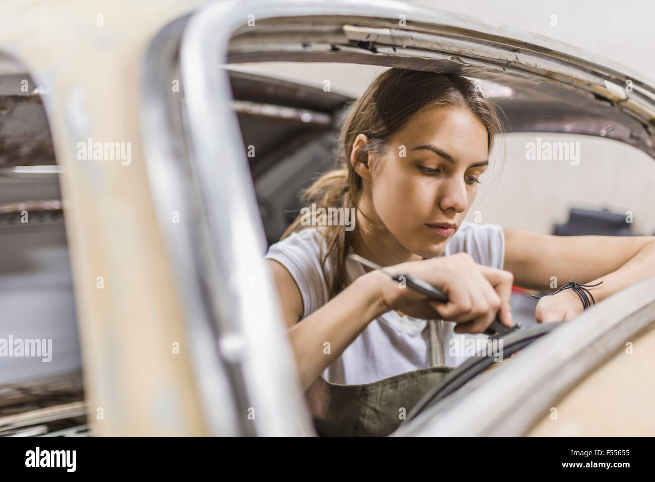 Femme mechanic repairing car au garage Banque D'Images