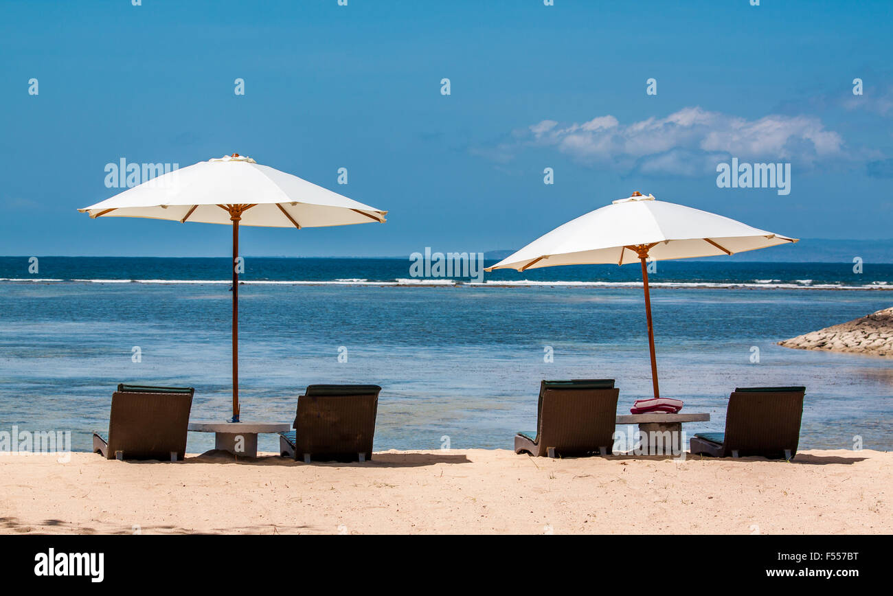 Chaises de plage avec parasols sur une plage de sable blanc tropicales Banque D'Images