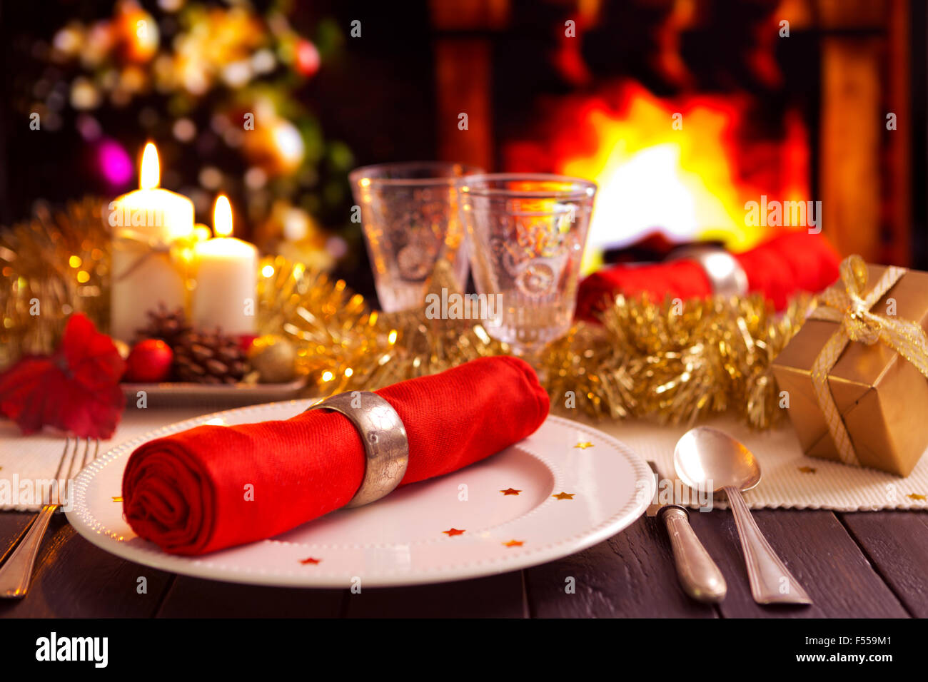 Une table de dîner de Noël romantique avec bougies et décorations de Noël. Un feu brûle dans la cheminée et Christm Banque D'Images