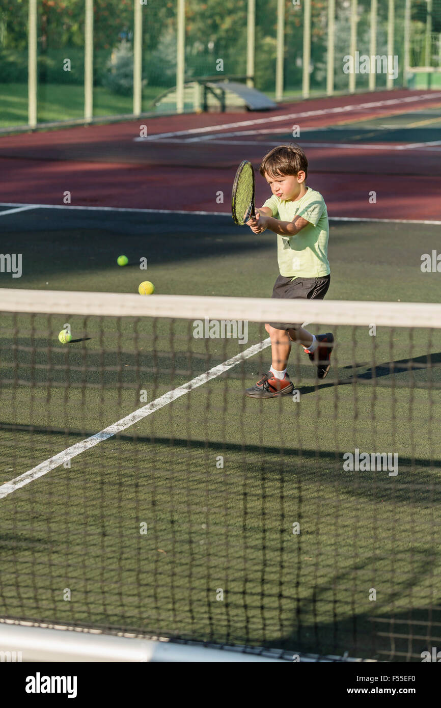 Garçon jouant au tennis sur terrain Banque D'Images