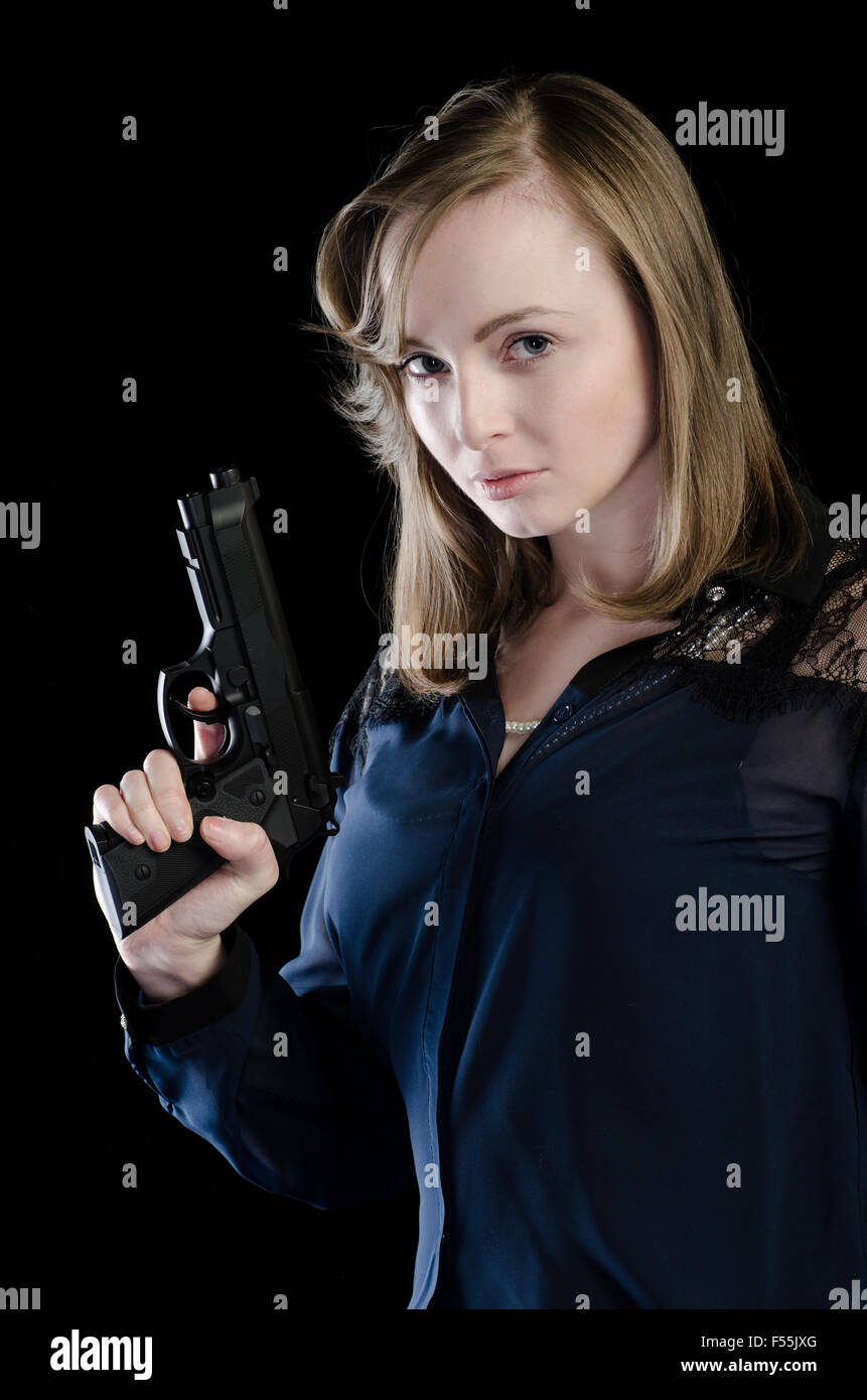 Jeune femme sérieuse tenant un pistolet armé Banque D'Images