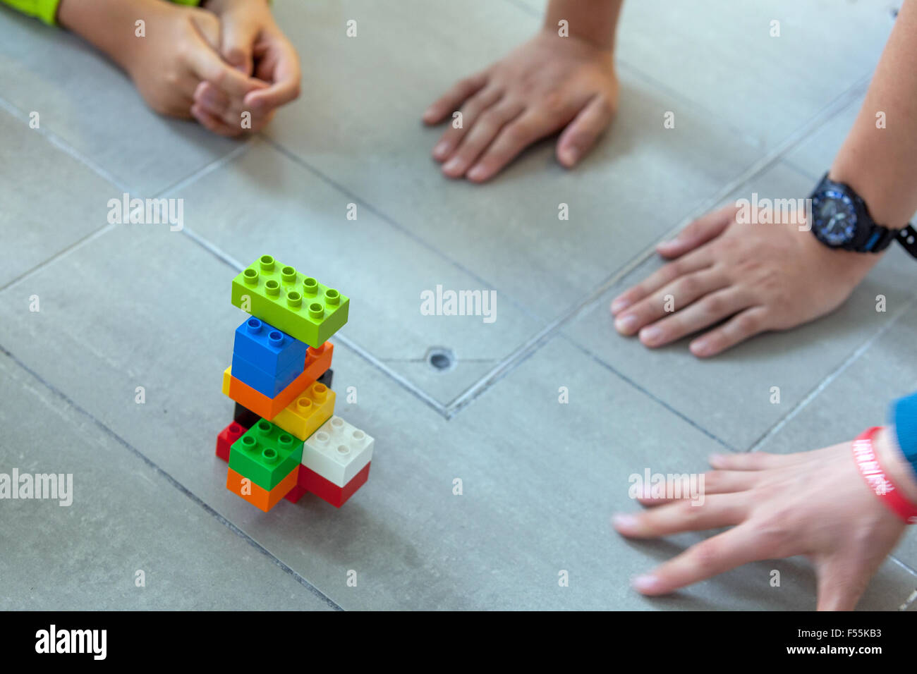 Les cubes en plastique dans les mains d'un jeu d'enfant qui développe la créativité et l'imagination, des briques lego enfants mains jouent avec des blocs lego Banque D'Images