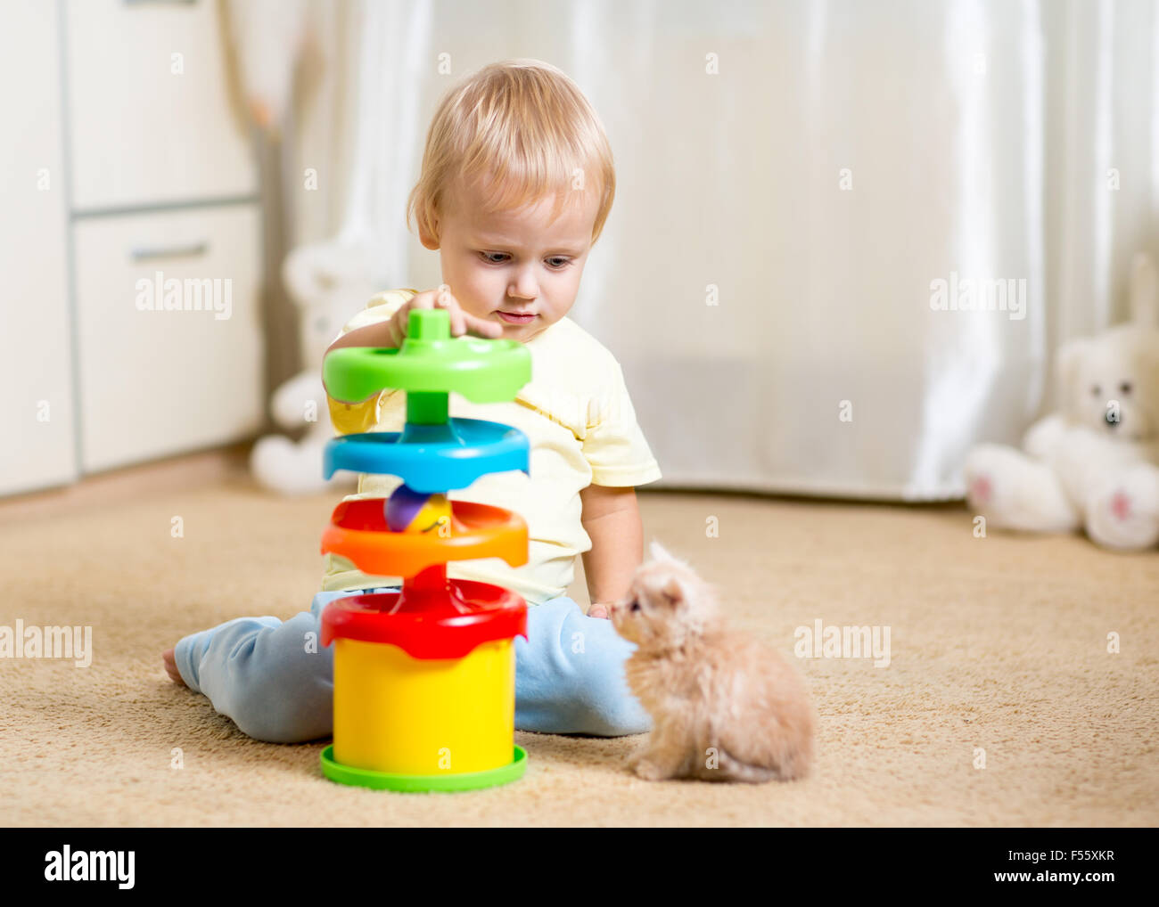 Garçon enfant joue avec un chaton, un intérieur Banque D'Images