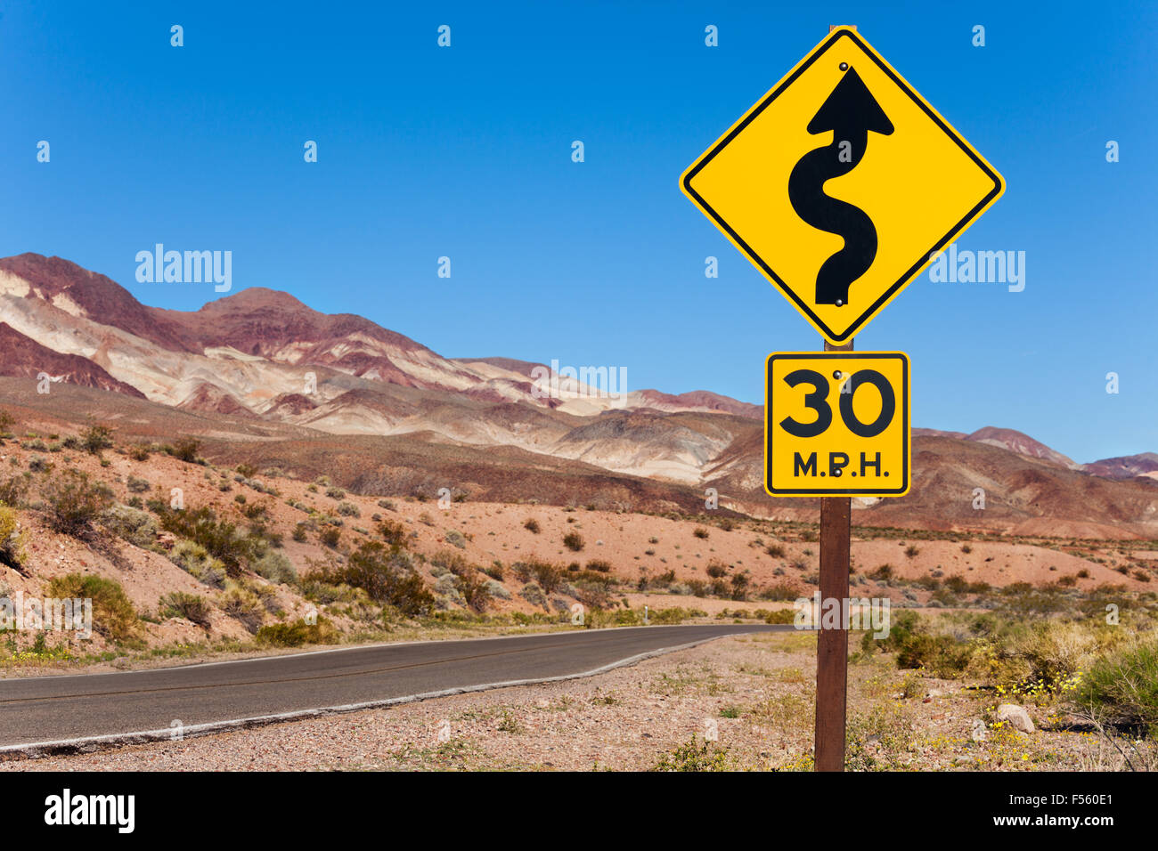 Panneau jaune avec flèche courbe et la route, en Californie Banque D'Images