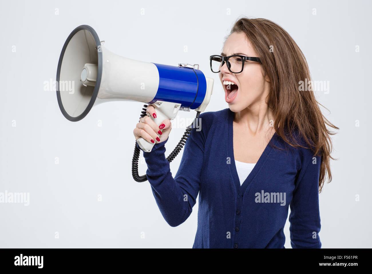 Portrait d'une jeune femme criant dans un mégaphone isolé sur fond blanc Banque D'Images
