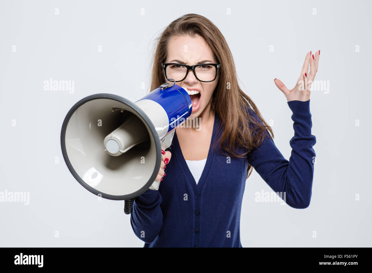 Portrait de femme en colère crier dans un mégaphone isolé sur fond blanc Banque D'Images