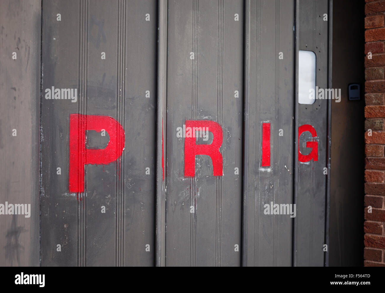 'PARKING' sur une porte métallique repliable vu de côté de façon à lire 'PRIG'. Banque D'Images