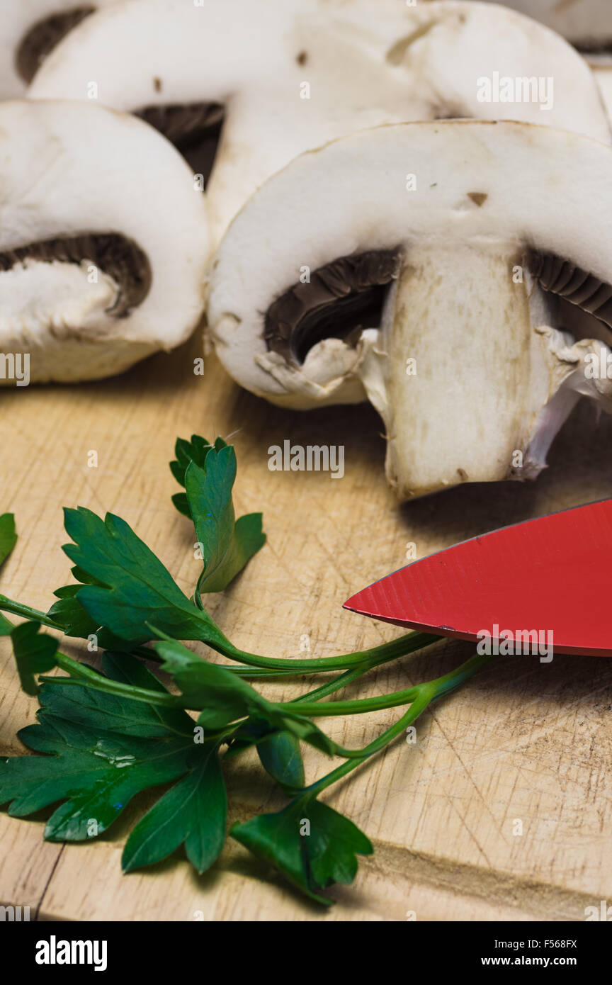 Champignons crus sur la planche à découper sur fond noir Banque D'Images