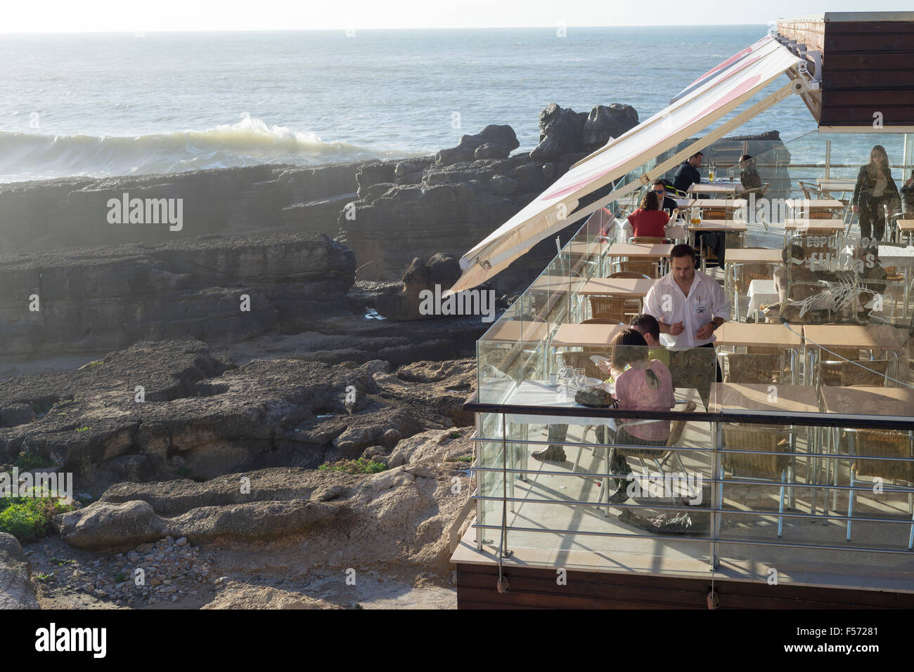 Les gens à l'intérieur restaurant donnant sur l'océan, Ericeira, Portugal Banque D'Images