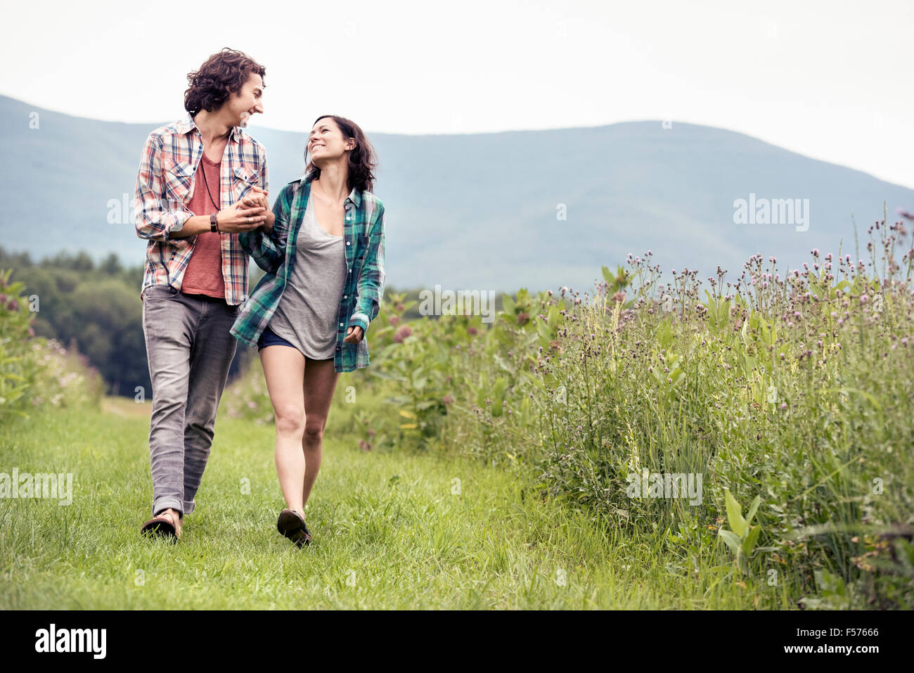 Un couple, homme et femme se promenant dans une prairie de la campagne. Banque D'Images