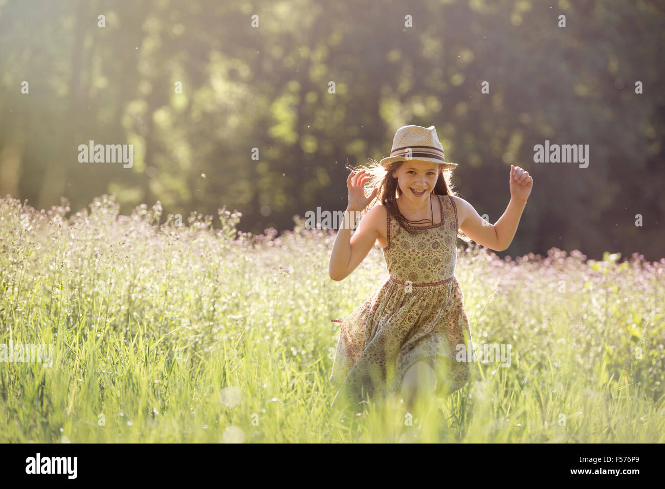 Une jeune fille qui marche dans un champ au soleil Banque D'Images